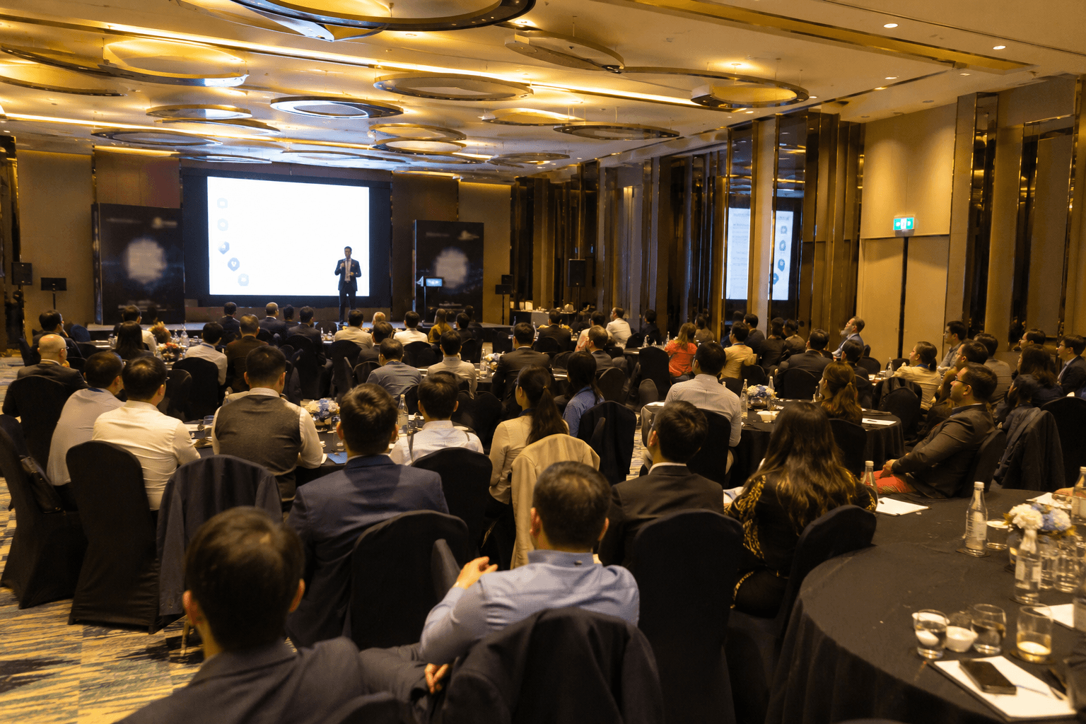 Corporate professionals attending a premium MICE conference event in a modern business convention hall